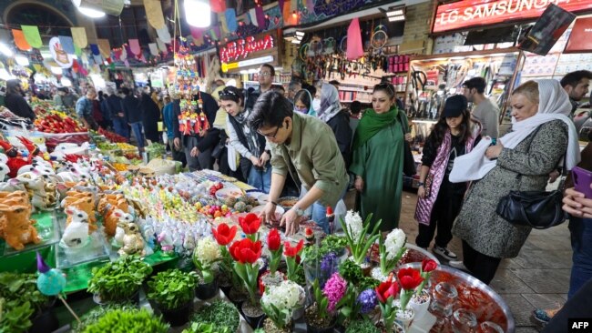 People shop at a market in Tehran on March 14, 2023, ahead of the Nowruz New Year festival. Millions of people across the Middle East, Asia and Eastern Europe celebrate Nowruz new year festival, which marks the start of spring.