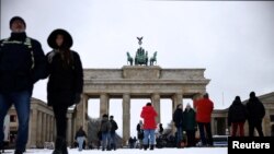 People walk in the snow at Brandenburg Gate in Berlin, Germany, Jan. 16, 2024. 