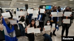Activistas sostienen carteles con los nombres de algunos de los más de 200 presos políticos liberados de Nicaragua, mientras esperan su llegada al Aeropuerto Internacional Dulles en Virginia, en las afueras de Washington, EEUU, el 9 de febrero de 2023.