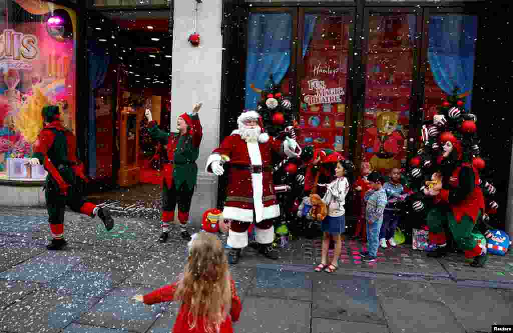 People dressed as Santa and his elves play with children invited to Hamleys toy store as it announces its&#39; potential top sellers for the Christmas season in London.