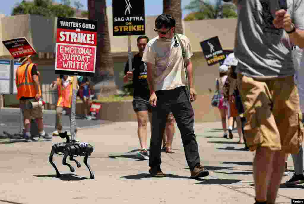 A robot dog named Gato moves with a sign on it as SAG-AFTRA actors and Writers Guild of America (WGA) writers walk the picket line during their ongoing strike outside Paramount Studios in Los Angeles, California, Aug. 2, 2023. 