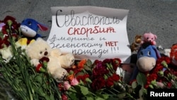 A makeshift memorial to victims of a missile strike is seen in Sevastopol, Russian-occupied Crimea, June 24, 2024. The placard reads: "Sevastopol mourns. No mercy for the United States and Zelenskyy!"