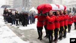 The immediate family of Brian Mulroney look on as RCMP pallbearers carry the casket to the funeral of the former prime minister, in Montreal, March 23, 2024.