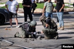 Israeli security personnel check the remains of a rocket in Shlomi, northern Israel, April 6, 2023.