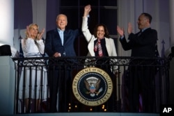 FILE - First lady Jill Biden and second gentleman Douglass Emhoff watch as President Joe Biden raises the hand of Vice President Kamala Harris while they view the Independence Day firework display from the White House, on July 4, 2024, in Washington. (AP Photo/Evan Vucci)