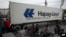 Taxi drivers walk past a truck blocking a street as part of an anti-gang protest in Port-au-Prince, Haiti, April 25, 2023.