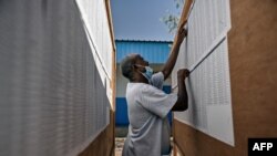 ARCHIVES - Un homme cherche son nom sur la liste électorale affichée au centre sur des panneaux d'affichage en bois au centre de vote Ecole Tour-Ousbo dans la capitale Djibouti le 9 avril 2021.