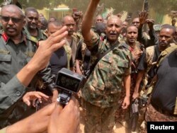 FILE - Sudan's General Abdel Fattah al-Burhan stands among troops, in an unknown location, in this picture released on May 30, 2023. (Sudanese Armed Forces/Handout via Reuters)