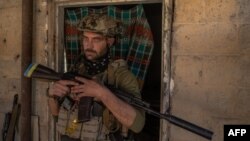 ইউক্রেনের জাপোরিঝিয়া অঞ্চলের ওরিখিভ শহরের কাছে অজ্ঞাত একটি স্থানে একজন ইউক্রেনীয় সেনা ছবির জন্য পোজ দিচ্ছেন। ১ অক্টোবর, ২০২৩।