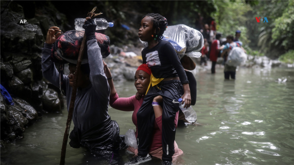 Migrantes haitianos atraviesan un río a su paso por el Tapón del Darién, desde Colombia a Panamá con el objetivo de llegar a Estados Unidos, el 9 de mayo de 2023.   