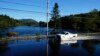 Sebuah mobil tampak melaju di jalan yang tergenang air akibat badai lee yang melanda wilayah Northeast Harbor, Maine, pada 17 September 2023. (Foto: AP/Robert F. Bukaty)