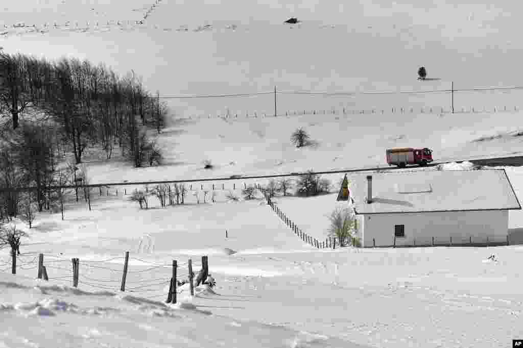 A firemen truck drives past a blanketed landscape after a recent snowfall in Roncesvalles, northern Spain.