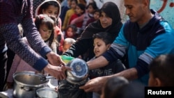 خوراک کے منتظر فلسطینی بچےرفح کے ایک کچن میں۔فوٹو رائٹرز