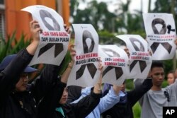 Aktivis menggelar poster saat unjuk rasa menentang pembatalan FIFA U-20 World Cup, di Jakarta, Jumat, 31 Maret 2023. (Foto: AP)