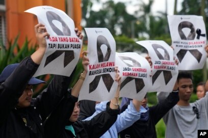 Aktivis menggelar poster saat unjuk rasa menentang pembatalan FIFA U-20 World Cup, di Jakarta, Jumat, 31 Maret 2023. (Foto: AP)