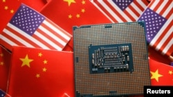 Foto ilutrasi yang menunjukkan sebuah unit semikonduktor CPU yang ditampilkan di depan bendera AS dan China. Foto diambil pada 17 Februari 2023. (Foto: Reuters/Florence Lo)