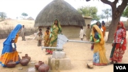 تھر میں گھروں کے قریب بانھہ بیلی کے تعمیر کردہ ایک واٹر پمپ سے خواتین پانی بھر رہی ہیں