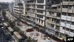 ঢাকায় একটি ভবনের অভ্যন্তরে বিস্ফোরণের একদিন পরে অগ্নিনির্বাপক ও জরুরি দলগুলি ধ্বংসাবশেষের মধ্যে কাজ করছে। (ছবি রেহমান আসাদ/এএফপি)