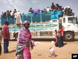 FILE — People board a truck as they leave Khartoum, Sudan, June 19, 2023.