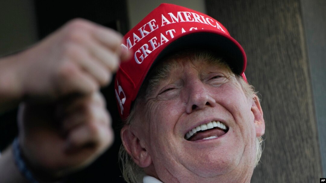 Former President Donald Trump laughs while looking over the 18th hole during the final round of the Bedminster Invitational LIV Golf tournament in Bedminster, NJ, Aug. 13, 2023. 