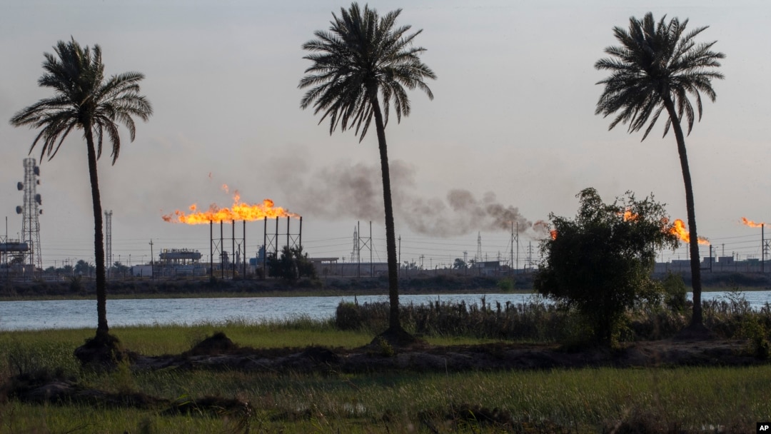 FILE - Flare stacks burn at the Nihran Bin Omar oil field, north of Basra, Iraq, March 22, 2023.
