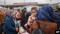 Syrians wait to cross into Syria from Turkey at the Cilvegozu border gate, near the town of Antakya, southeastern Turkey, Feb. 21, 2023.