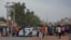 People gather on the street in east Khartoum on Apr. 16, 2023, as fighting in Sudan raged for a second day in battles between rival generals. 