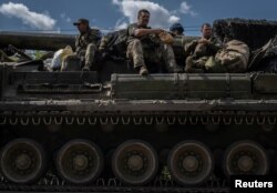 Ukrainian servicemen sit in a military vehicle, amid Russia's attack on Ukraine, near the Russian border in Sumy region, Ukraine Aug. 11, 2024.