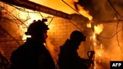乌克兰消防人员在俄罗斯轰击赫尔松市后给一栋房屋灭火。（2023年12月24日）