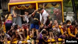 Filipino devotees fight to get on the cart that carries the statue of the Black Nazarene during its yearly procession in Manila.
