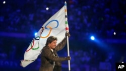 Tom Cruise carries the Olympic flag during the 2024 Summer Olympics closing ceremony at the Stade de France, Aug. 11, 2024, in Saint-Denis, France. 