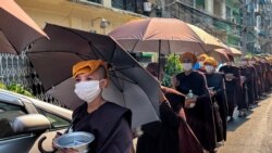 Para biarawati Buddha mengumpulkan sedekah dengan kepala ditutupi handuk dan payung untuk berlindung dari sinar matahari saat gelombang panas melanda Yangon pada 24 April 2023. (Foto: AFP)