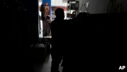 Un cliente compra ropa en una tienda sin electricidad debido a un corte de energía programado ordenado por el Ministerio de Energía, en Quito, Ecuador, el 16 de abril de 2024.