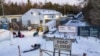 This aerial view shows migrants from Venezuela, Nigeria, Haiti and other countries arriving at the Roxham Road border crossing in Roxham, Quebec, on March 3, 2023.