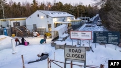 FILE - This aerial view shows migrants arriving at the Roxham Road border crossing in Roxham, Quebec, on March 3, 2023. (Photo by Sebastien ST-JEAN / AFP)