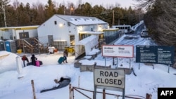 This aerial view shows migrants from Venezuela, Nigeria, Haiti and other countries arriving at the Roxham Road border crossing in Roxham, Quebec, on March 3, 2023.