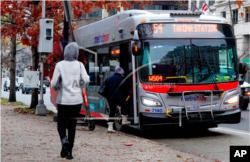 Passengers board a Metrobus in downtown Washington, Wednesday, Dec. 7, 2022.
