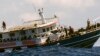 Orang-orang di atas kapal nelayan melambaikan tangan saat didekati oleh awak kapal penyelamat Geo Barents Selasa, 4 April 2023, di perairan internasional lepas pantai Libya. (AP/Salvatore Cavalli)