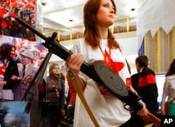 FILE - A member of the pro-Kremlin youth movement Nash holds a Soviet World War II-era Degtyaryov light machine gun at the movement's congress in Moscow, Dec. 25, 2007. Ukrainian volunteers are using the old gun to knock down Iranian-made drones during Russia's invasion of their country.