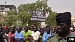 Мужчина держит плакат с требованием к солдатам армии США покинуть Нигер без переговоров во время демонстрации в Ниамее, 13 апреля 2024 года.