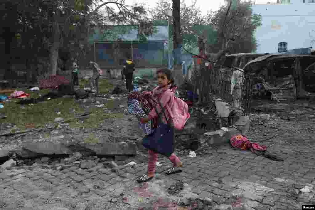 A girl carrying her belongings walks in the area of Al-Ahli hospital where hundreds of Palestinians were killed in a blast that Israeli and Palestinian officials blamed on each other, and where Palestinians who fled their homes were sheltering, in Gaza City.&nbsp;REUTERS/Mohammed Al-Masri&nbsp;