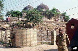FILE - In this Oct. 29, 1990, file photo, security officers guard the Babri Mosque in Ayodhya, closing off the disputed site claimed by Muslims and Hindus.