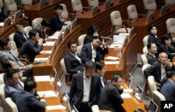 Ekspresi para anggota parlemen dari oposisi utama Partai Demokrat saat parlemen mengeluarkan mosi untuk menyetujui surat perintah penangkapan pemimpin mereka Lee Jae-myung di Majelis Nasional di Seoul, Korea Selatan, Kamis, 21 September 2023. (AP /Ahn Young-joon)