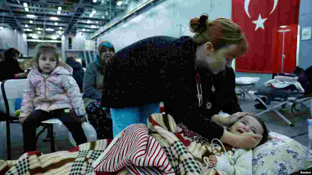 A child suffering from exposure rests in a makeshift hospital bed that has been set up in the Turkish military ship TCG Bayraktar in the aftermath of a deadly earthquake. The ship is docked in a port in the province of Hatay, in Iskenderun, Turkey.