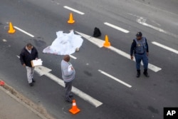 A covered corpse lays in a road on the outskirts of Cape Town, South Africa, Aug. 7, 2023. Unrest in the area followed an announcement of a strike by minibus taxi drivers angered at what they call heavy-handed tactics by police and city authorities.