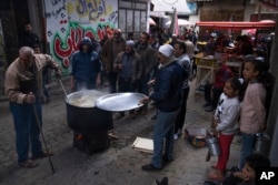 Warga Palestina, Walid Hattab tengah memasak makanan berbuka puasa berupa sup dan bubur gandum untuk penduduk yang kurang mampu (dok: AP)