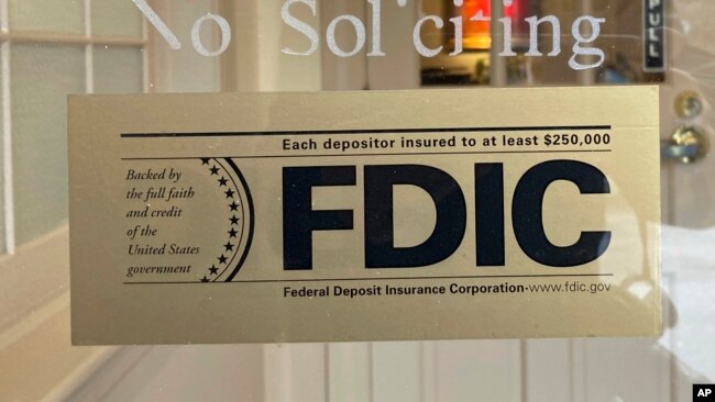 FILE - An FDIC sign is posted on a window at a Silicon Valley Bank branch in Wellesley, Mass., March 11, 2023.