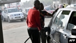 FILE - A fuel attendant fills a tank at a fuel station in Kano, northwest Nigeria, on Feb. 8, 2023.