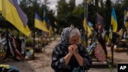 Svitlana Sushko, de 62 años, llora mientras visita la tumba de su hijo menor, un soldado ucraniano que murió el año pasado en la guerra contra Rusia, en Kiev, Ucrania, el jueves 3 de agosto de 2023. (Foto AP/Jae C. Hong )