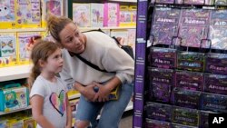 FILE - Quinn Byrne, 5 left, shops with her mother, Jamie Byrne, at a Learning Express store in Lake Zurich, Ill., Tuesday, Sept. 26, 2023. 